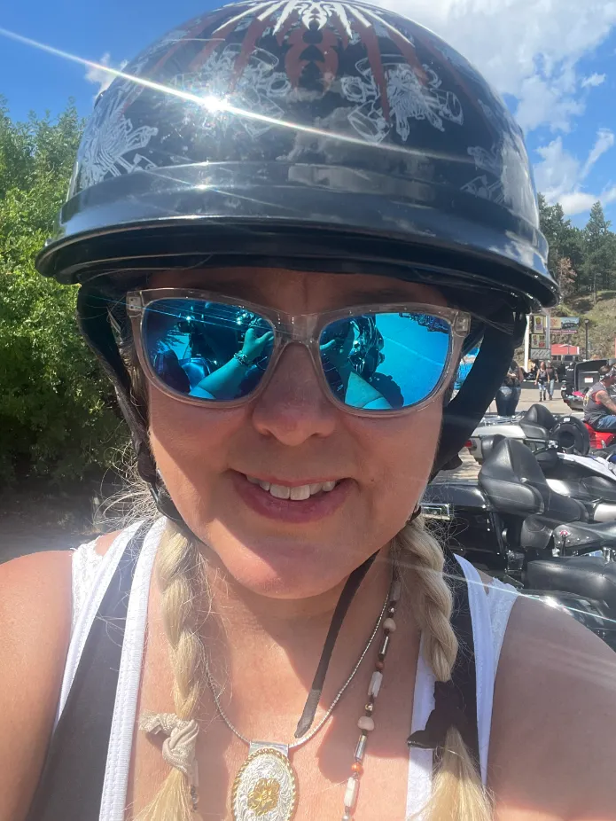Sheral DeVaughn in a biker helmet in front of motorbikes